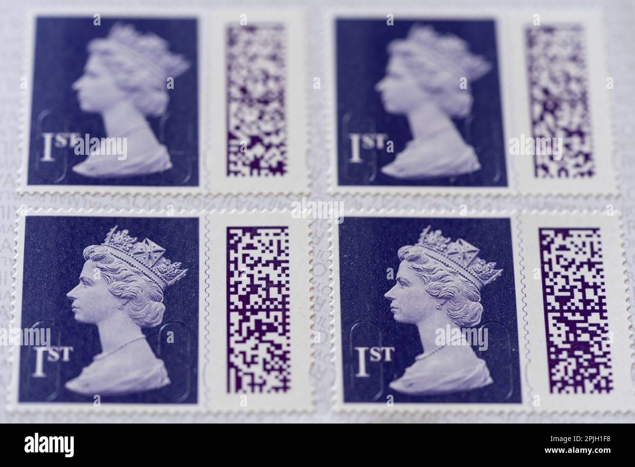 Un libro aperto di timbri autoadesivi di prima classe colorati in indaco che mostrano i codici Queen Elizabeth II e QR. Marzo 2023, Regno Unito. Foto Stock