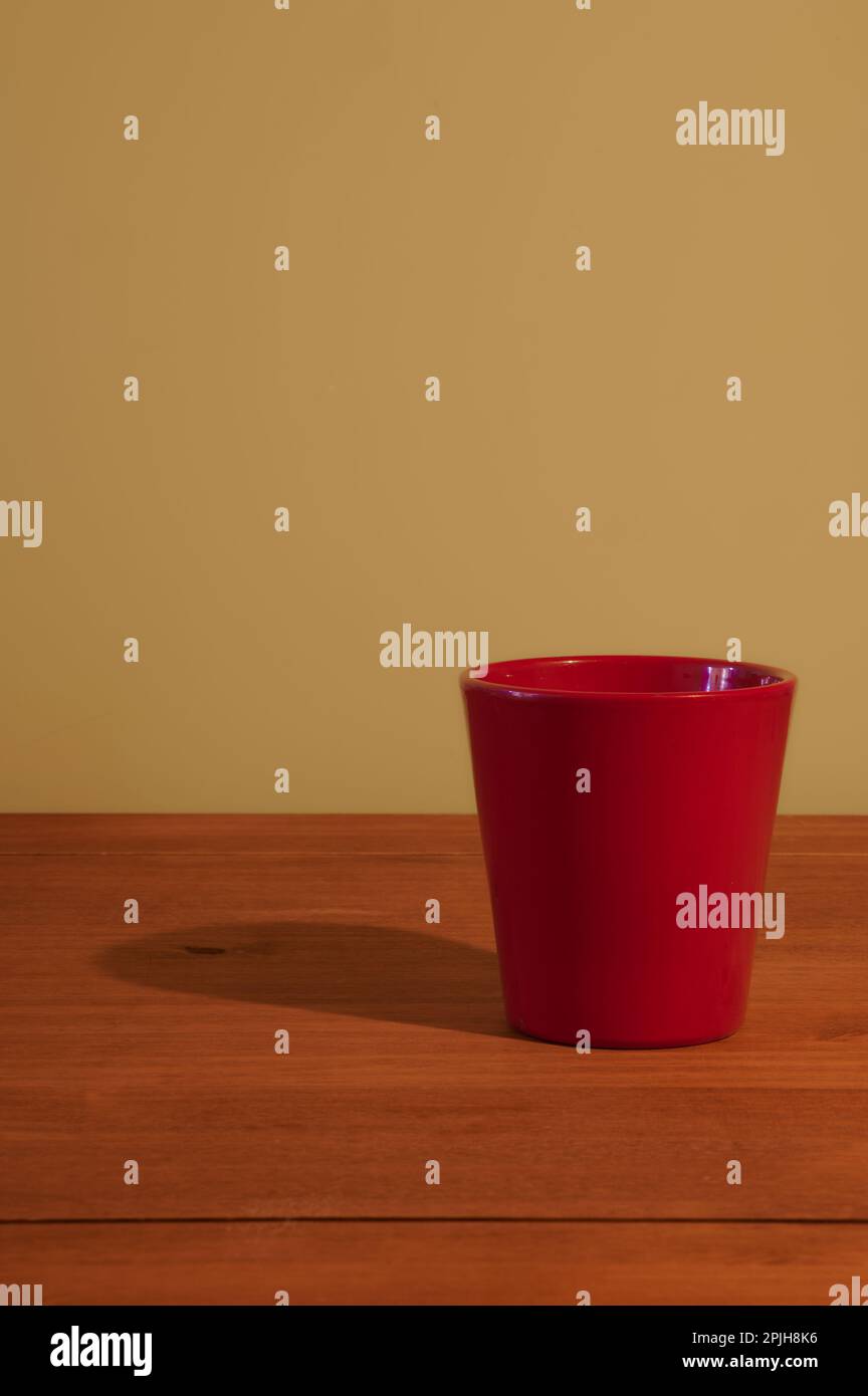 vaso rosso su un tavolo di legno vuoto Foto Stock