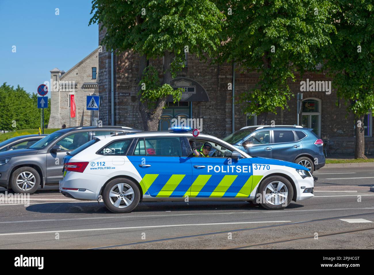 Tallinn, Estonia - Giugno 16 2019: Ufficiale in una macchina di polizia che chiede ai conducenti di fermarsi per far passare un convoglio diplomatico. Foto Stock