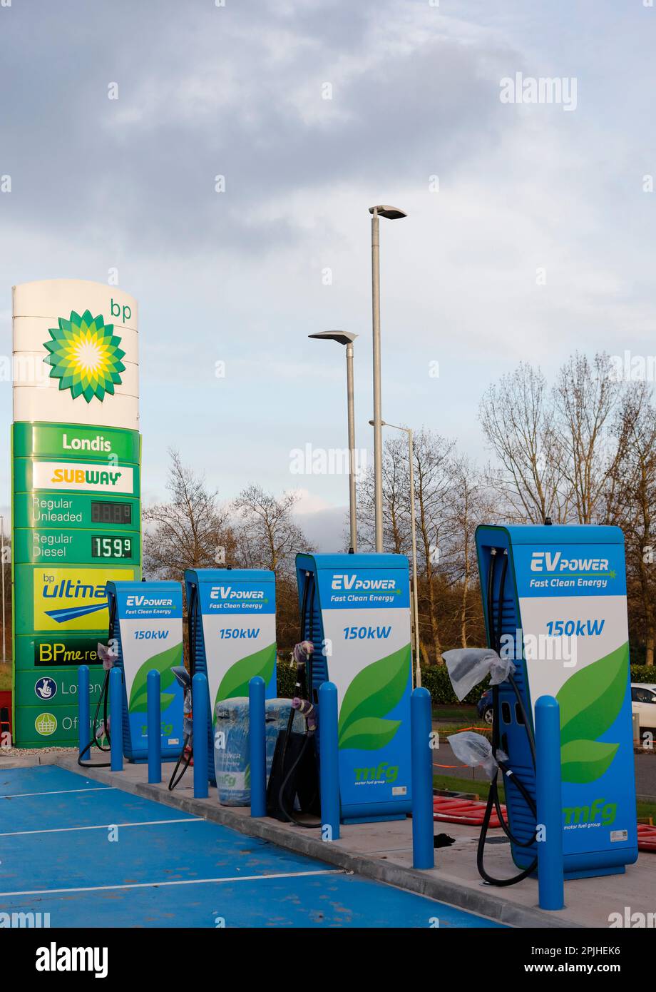 Vani di ricarica per veicoli elettrici BP EV installati nel piazzale della stazione di servizio BP - punti di ricarica per veicoli elettrici nei piazzali delle stazioni di servizio, Regno Unito Foto Stock