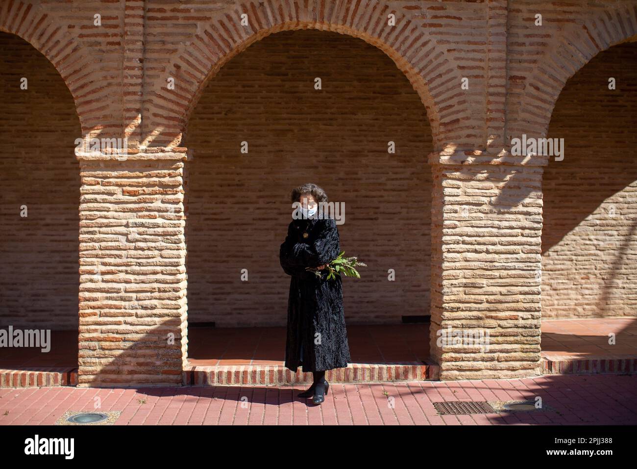 Una donna tiene un ramo di alloro, in uno degli archi della chiesa di San Lorenzo in Sahagún. La processione delle Palme rappresenta il passaggio di Gesù al suo trionfante ingresso a Gerusalemme. La processione ha girato le strade della città accompagnata da fedeli con bouquet e la band sinfonica della città. Credit: SOPA Images Limited/Alamy Live News Foto Stock