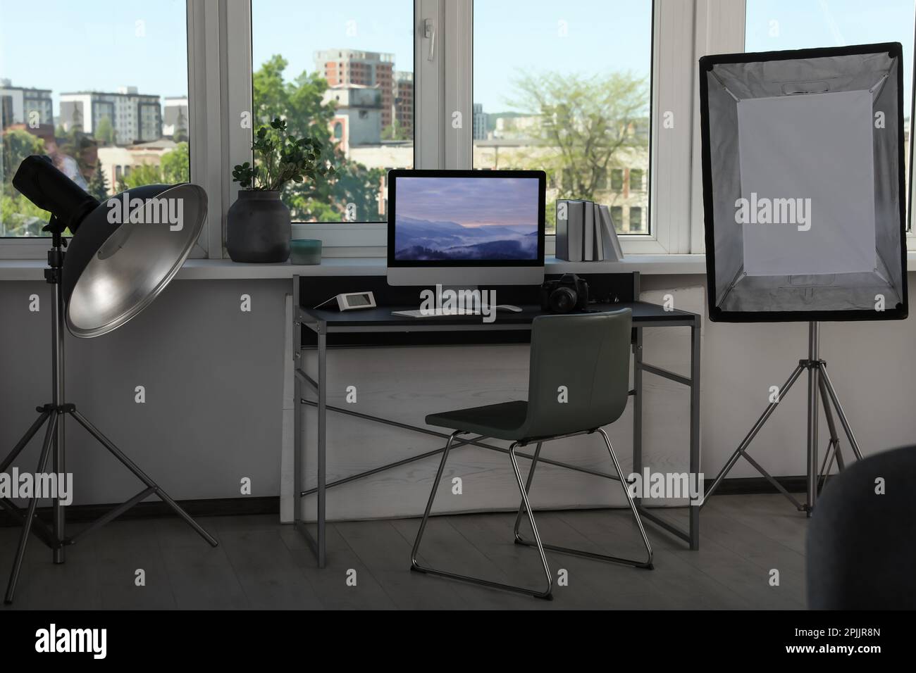 Apparecchiature di illuminazione professionali e comodo posto di lavoro in studio fotografico. Design degli interni Foto Stock