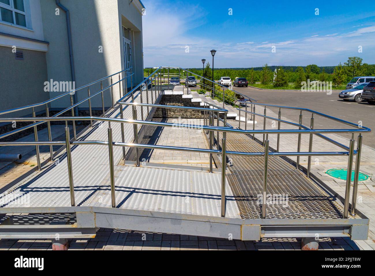 Una rampa per sedie a rotelle o parapetto per passeggino è un piano inclinato installato in aggiunta alle scale, messa a fuoco selettiva Foto Stock