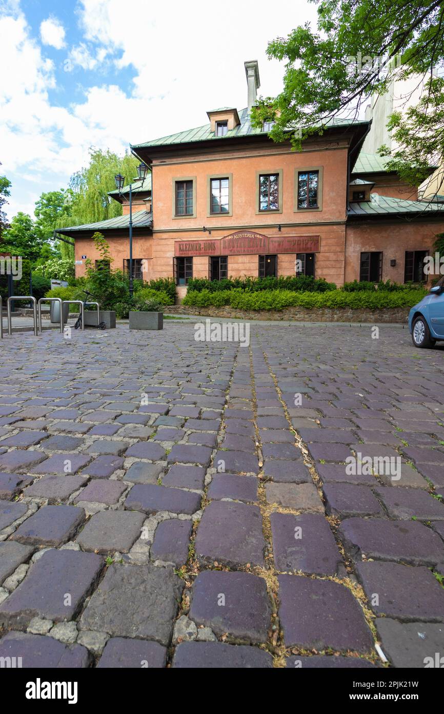 26-05-2022. cracovia-polonia. Un ristorante nel quartiere ebraico di Cracovia - Kazimierz, visto da un angolo basso tra cui gli antichi pavimenti in pietra Foto Stock