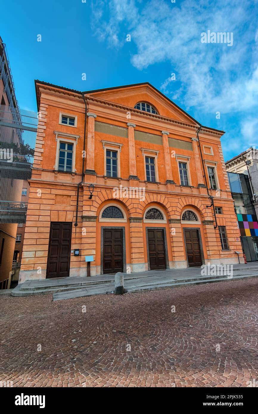 Vista esterna dell'edificio storico arancione sotto il cielo blu nel centro storico di Alba, Piemonte, Italia settentrionale. Foto Stock