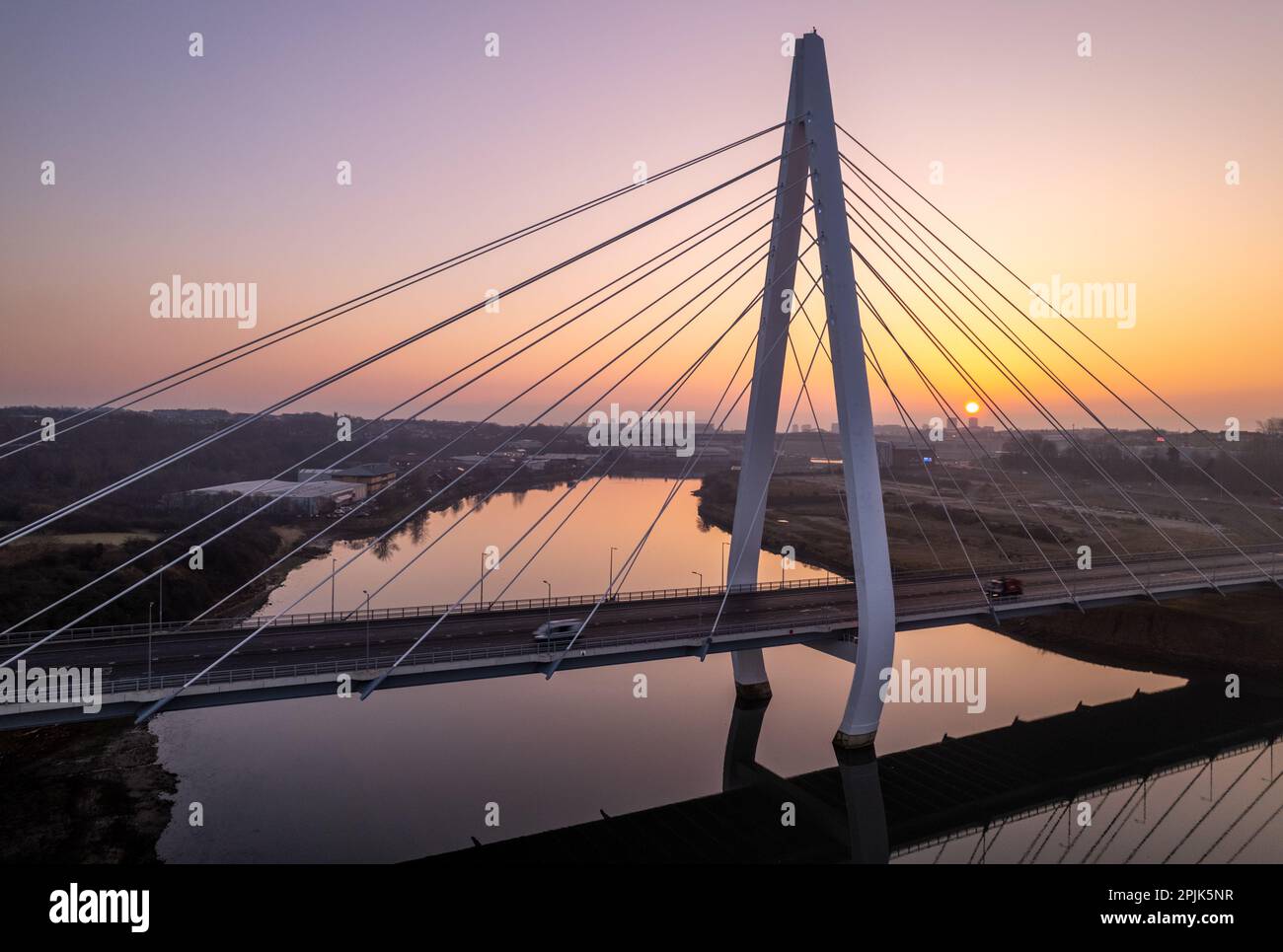 Fuco di traffico che attraversa il Northern spire Bridge durante un'alba invernale misteriosa Foto Stock