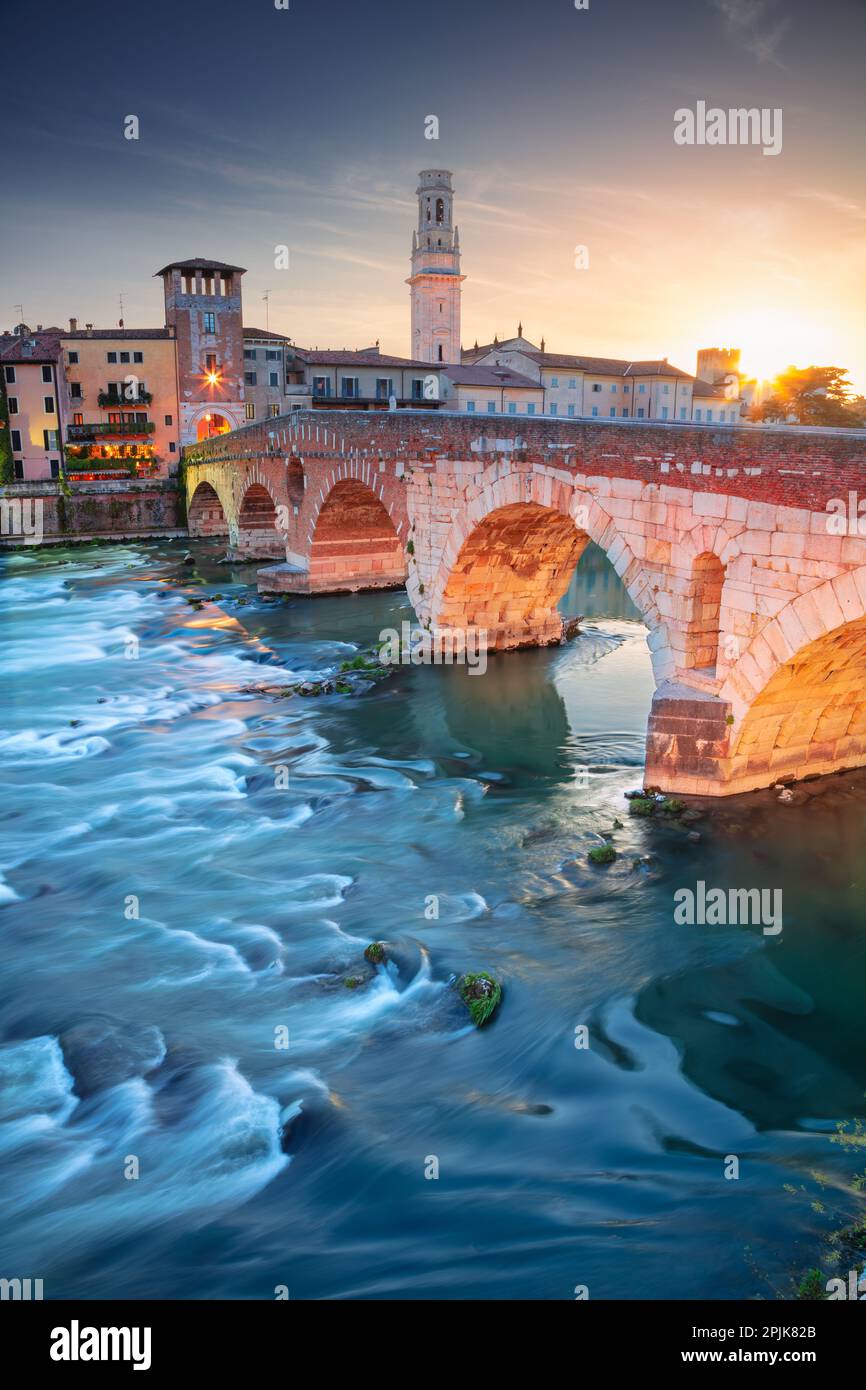 Verona, Italia. Immagine della città di Verona con il Ponte di pietra sul fiume Adige al tramonto. Foto Stock