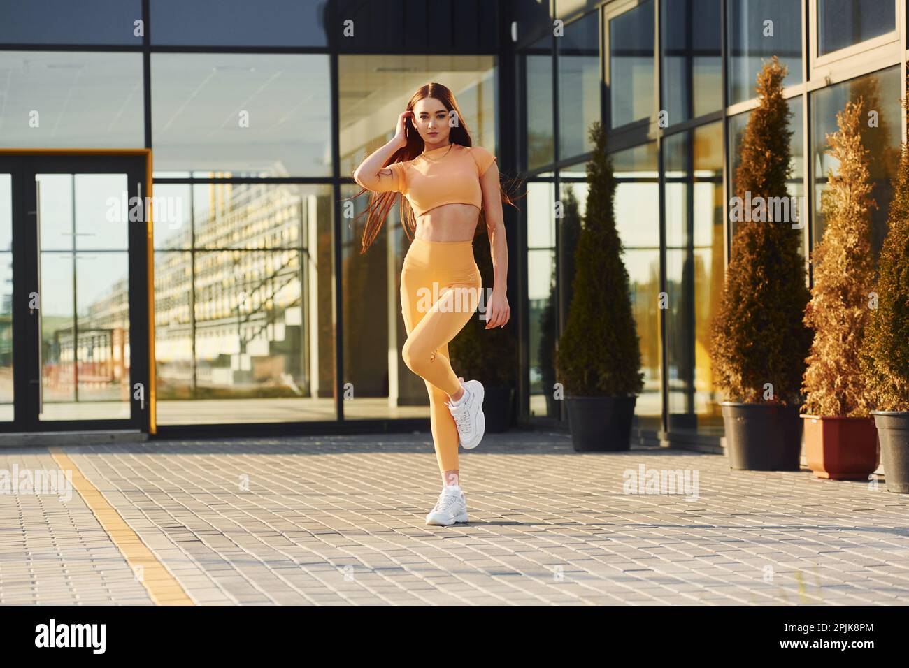 Esterno moderno. Giovane donna in abbigliamento sportivo hanno sessione di fitness all'aperto Foto Stock