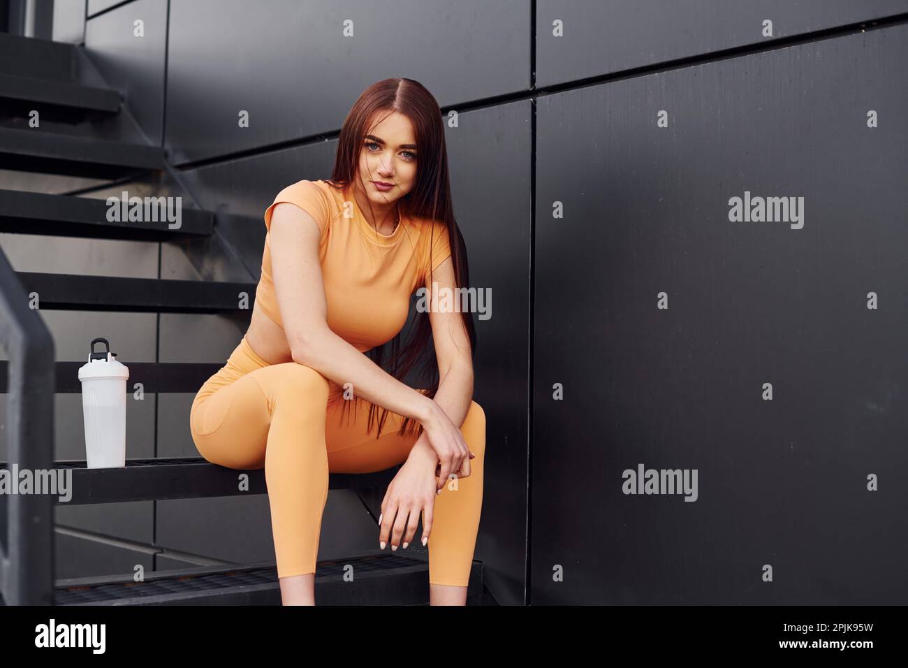 Esterno moderno di colore nero. Giovane donna in abbigliamento sportivo hanno sessione di fitness all'aperto Foto Stock