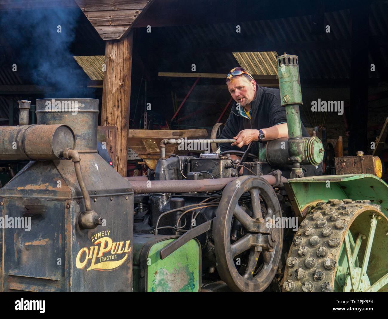 Uomo che guida un trattore d'epoca al Museum of Rural Life, Lamport Hall, Northamptonshire, Regno Unito Foto Stock