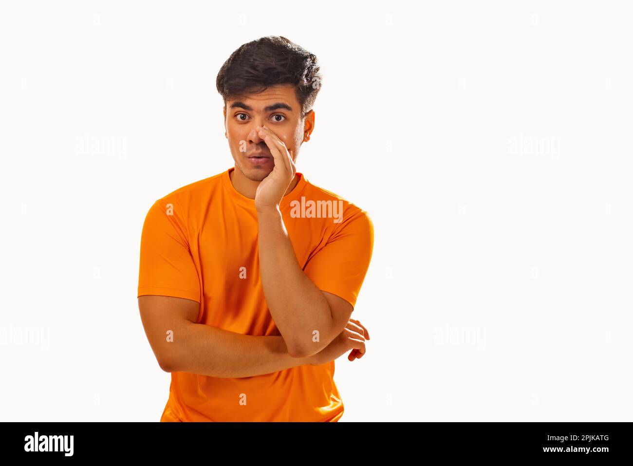 Giovane donna che chiama qualcuno con la mano accanto alla bocca su sfondo bianco Foto Stock