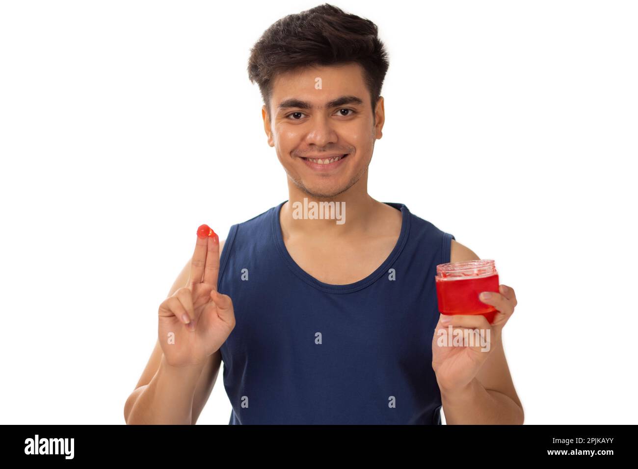 Ritratto di giovane uomo che applica gel per capelli su sfondo bianco Foto Stock