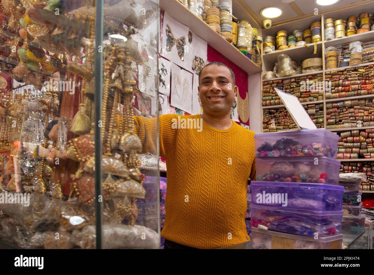 Ritratto di un allegro custode del negozio in piedi presso la sua negozio di merletti Foto Stock