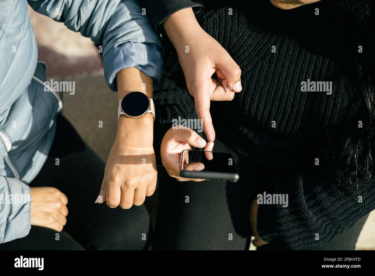 Tre persone latine che utilizzano i loro dispositivi mobili e interagiscono tra loro Foto Stock