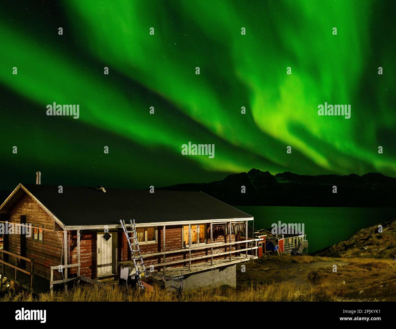 Aurora boreale sull'insediamento di Kuummiit. Area di Ammassalik nella Groenlandia orientale, territorio danese Foto Stock