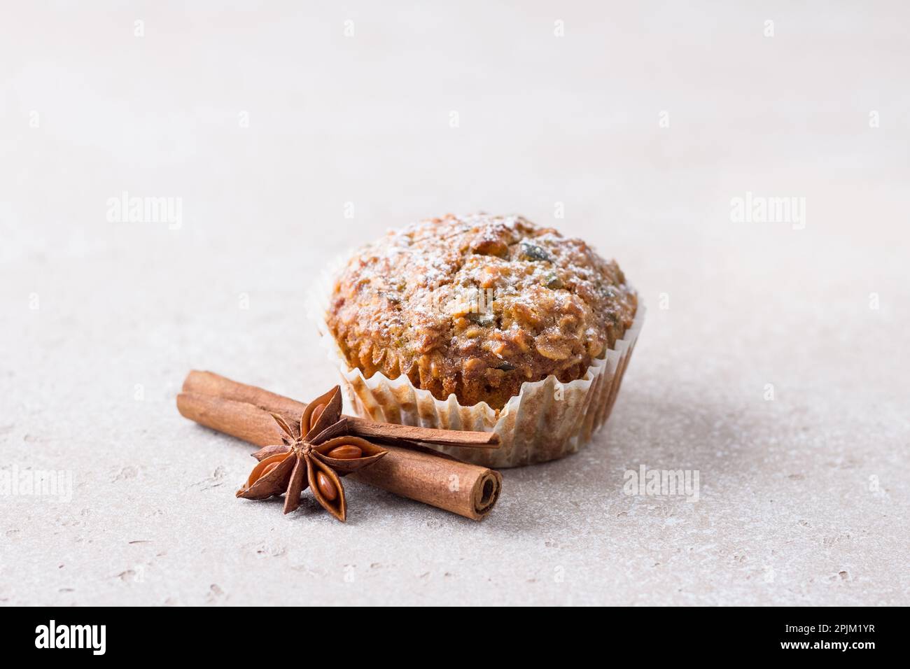 Muffin di zucca appena sfornati fatti in casa con farinata d'avena e noci su uno sfondo beige textured, spazio Foto Stock