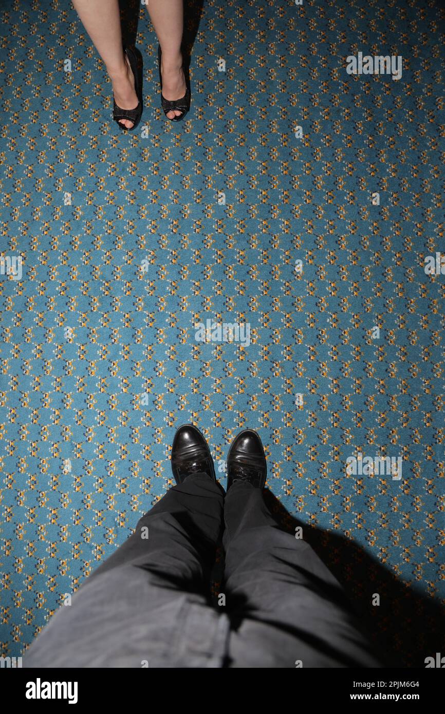 Vista dall'alto dei piedi femminili e maschili nelle scarpe, in piedi l'uno di fronte all'altro; possibilità di utilizzo concettuale Foto Stock