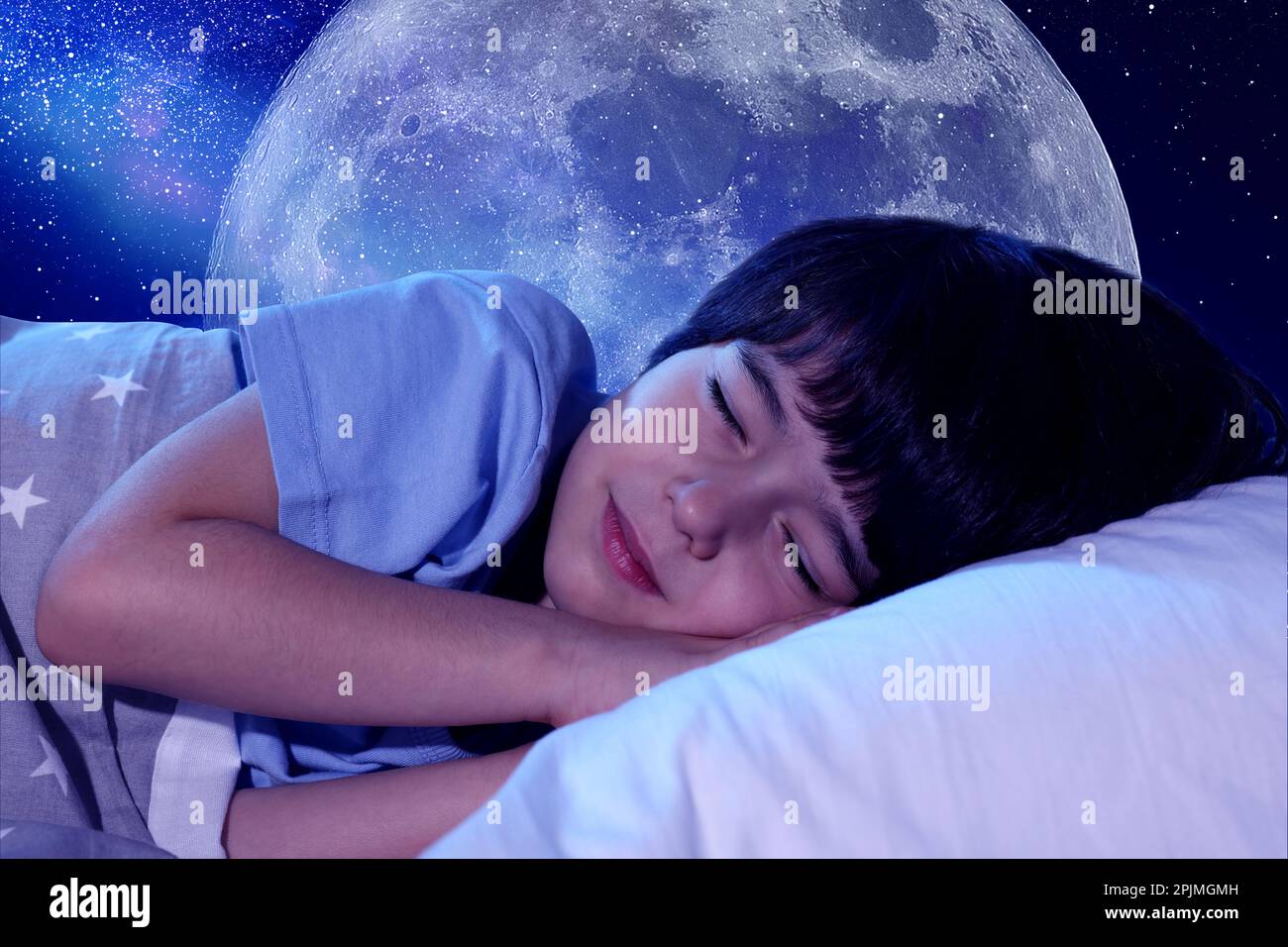 Carino ragazzino che dorme a letto e bel cielo stellato con luna piena di notte sullo sfondo Foto Stock
