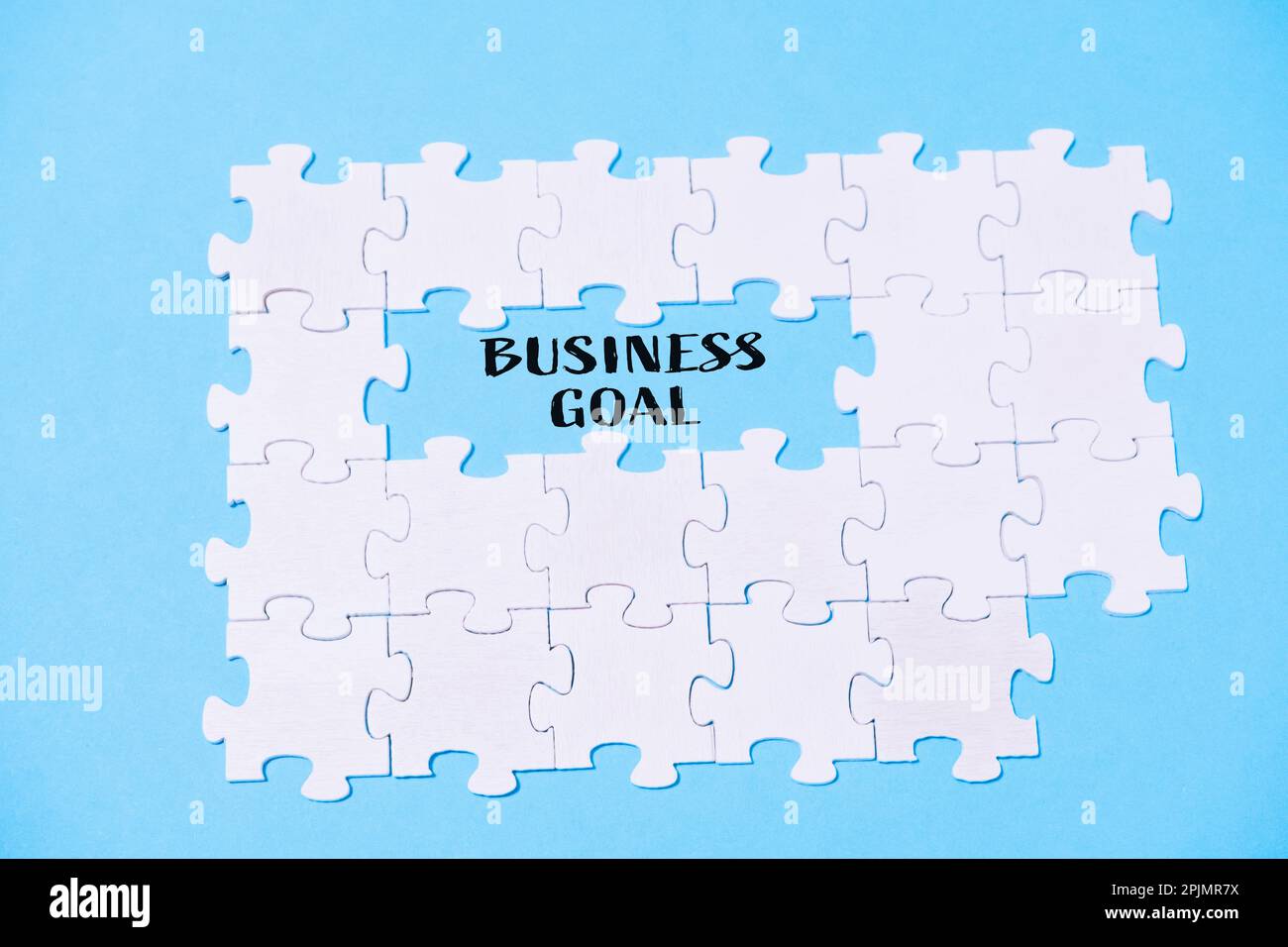 Business text BUSINESS OBIETTIVO SU sfondo blu con puzzle bianchi Foto Stock