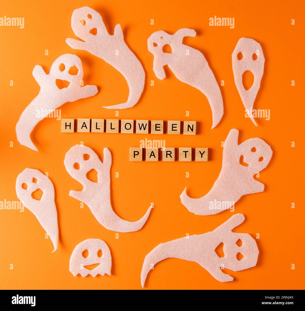 Fantasmi bianchi per la festa di Halloween. Fantasma di carta su sfondo arancione. Fumetto Creepy Whisper. Fai-da-te fatto a mano. Impostare i caratteri boo. Parola frase di legno della lettera. Fantasma di Halloween spettrale Foto Stock
