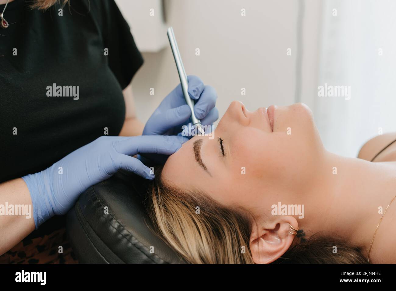 Donna che riceve microblading sulle sopracciglia da estetista Foto Stock