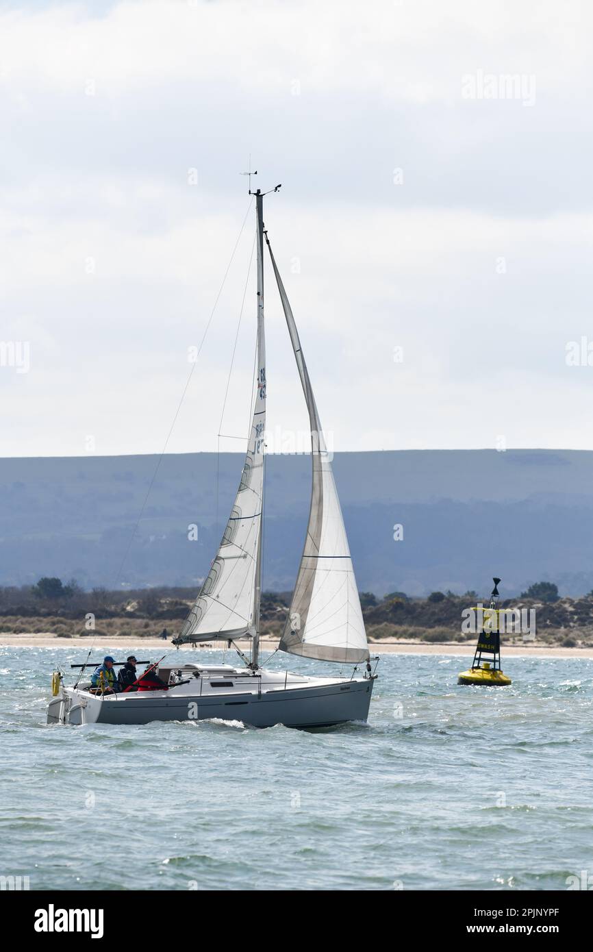 Yacht che entra nel porto di Poole dalla baia di Bournemouth e passa il Buoy oscillante no 9 che è un marcatore cardinale occidentale che avverte di pericolo sotto il IAL Foto Stock