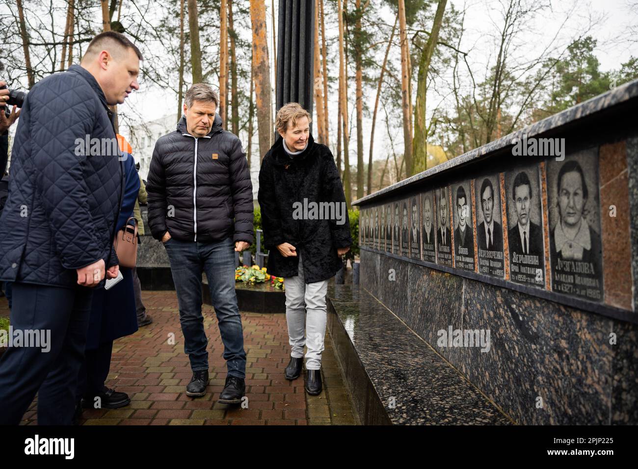 03 aprile 2023, Ucraina, Slawutytsch: Robert Habeck (Bündnis 90/Die Grünen, M), ministro federale dell'economia e della protezione del clima, visita il memoriale di Cernobyl con Anka Feldhusen (r), ambasciatore tedesco in Ucraina, e Yuri Fomitschow (l), sindaco del comune di Slavutych. La cittadina fu ricostruita alla fine degli anni '1980s a seguito dell'incidente della centrale nucleare di Cernobyl (NPP), che si è verificato a circa 45 chilometri a est. La città servì come nuova casa per i lavoratori della centrale nucleare, attiva fino al 2000, dopo che la vecchia città di Prypyat fu evacuata. La città Foto Stock