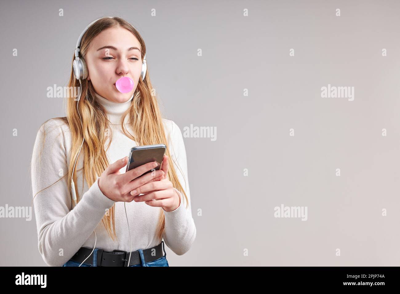 Ragazza giovane che ascolta musica in streaming contenuti divertirsi a guardare video divertirsi a parlare con gli amici facendo gesti volti utilizzando l' Foto Stock