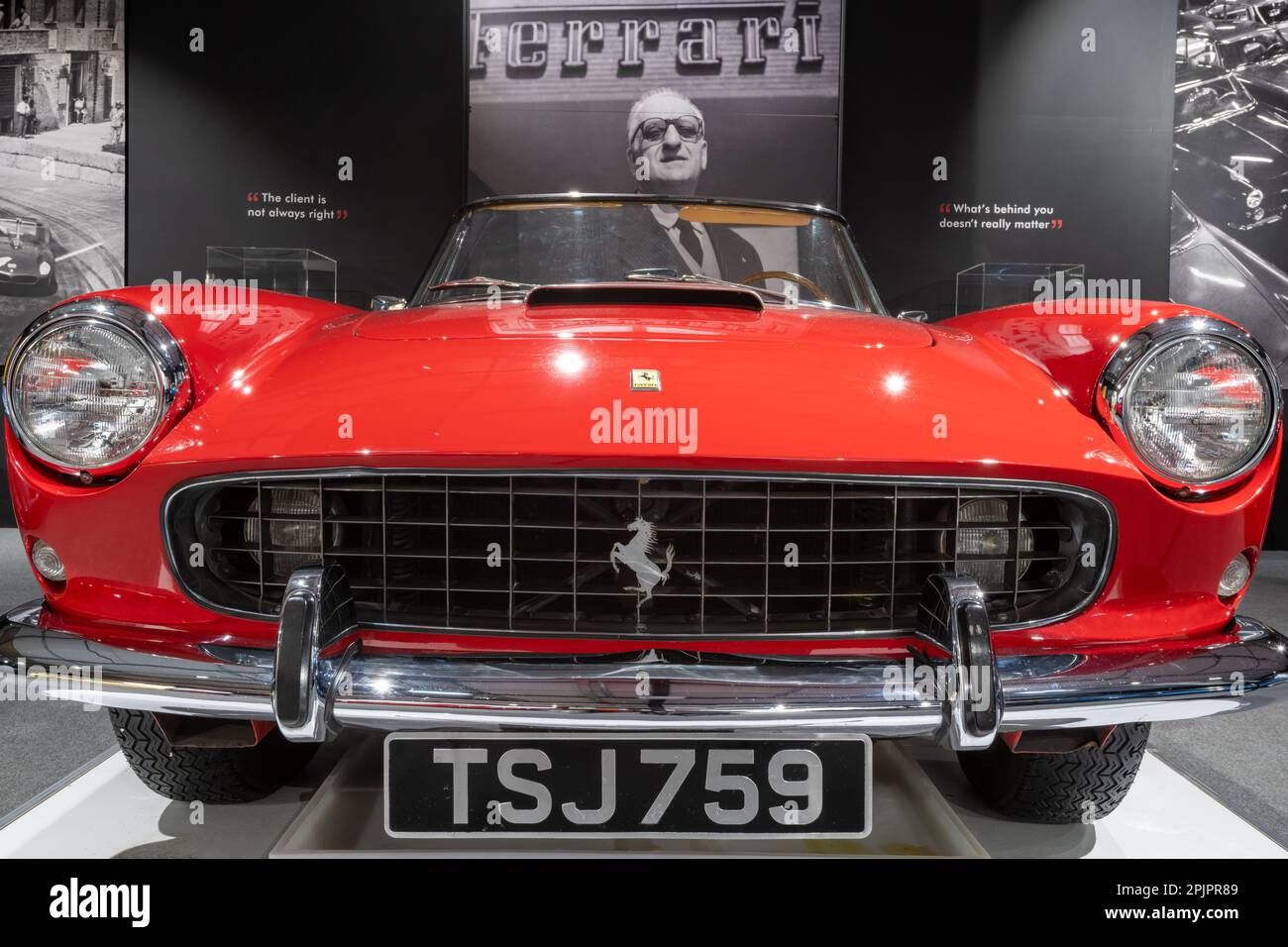 Sparkford.Somerset.United Kingdom.March 26th 2023.A 1960 Ferrari 250 GT cabriolet è in mostra davanti ad un ritratto di Enzo Ferrari al Haynes Moto Foto Stock