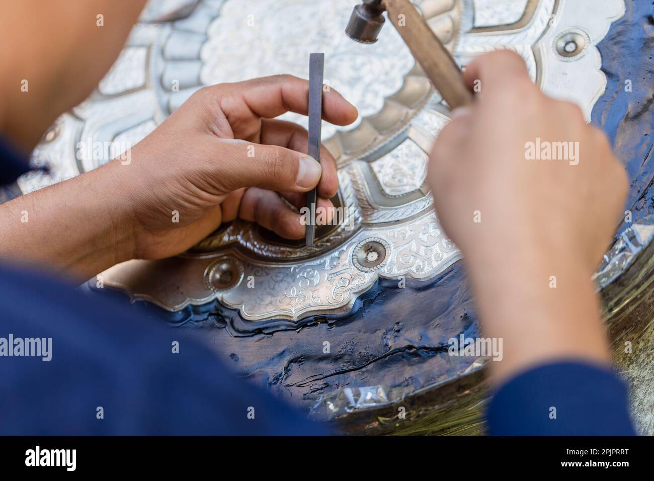 Un disegno di incisione dell'artista sul vassoio di metallo, officina di strada. Samarcanda, Uzbekistan Foto Stock
