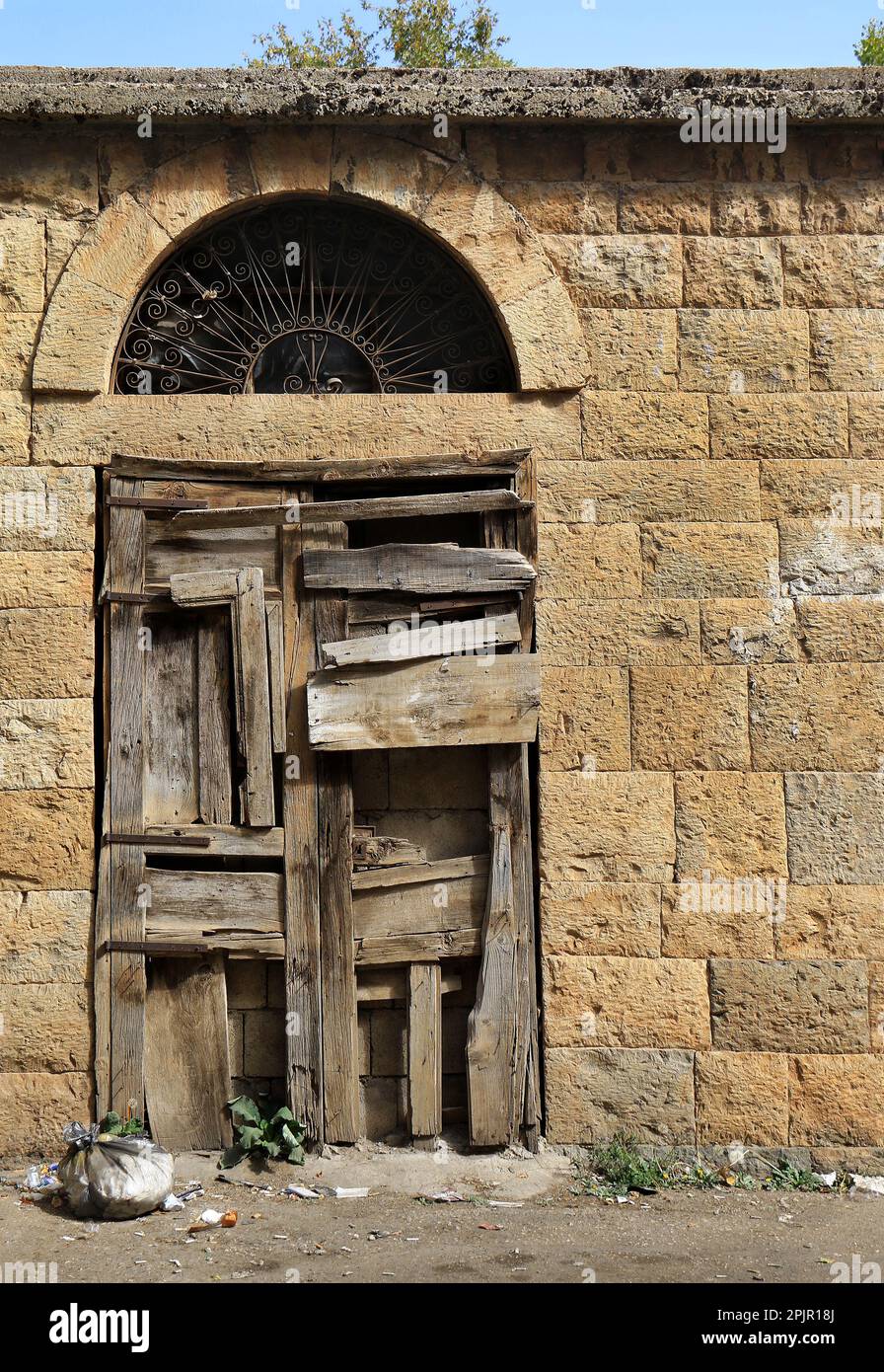 Una porta di legno chiusa con molte lastre con un arco sopra, tipici dettagli architettonici libanesi. Foto Stock