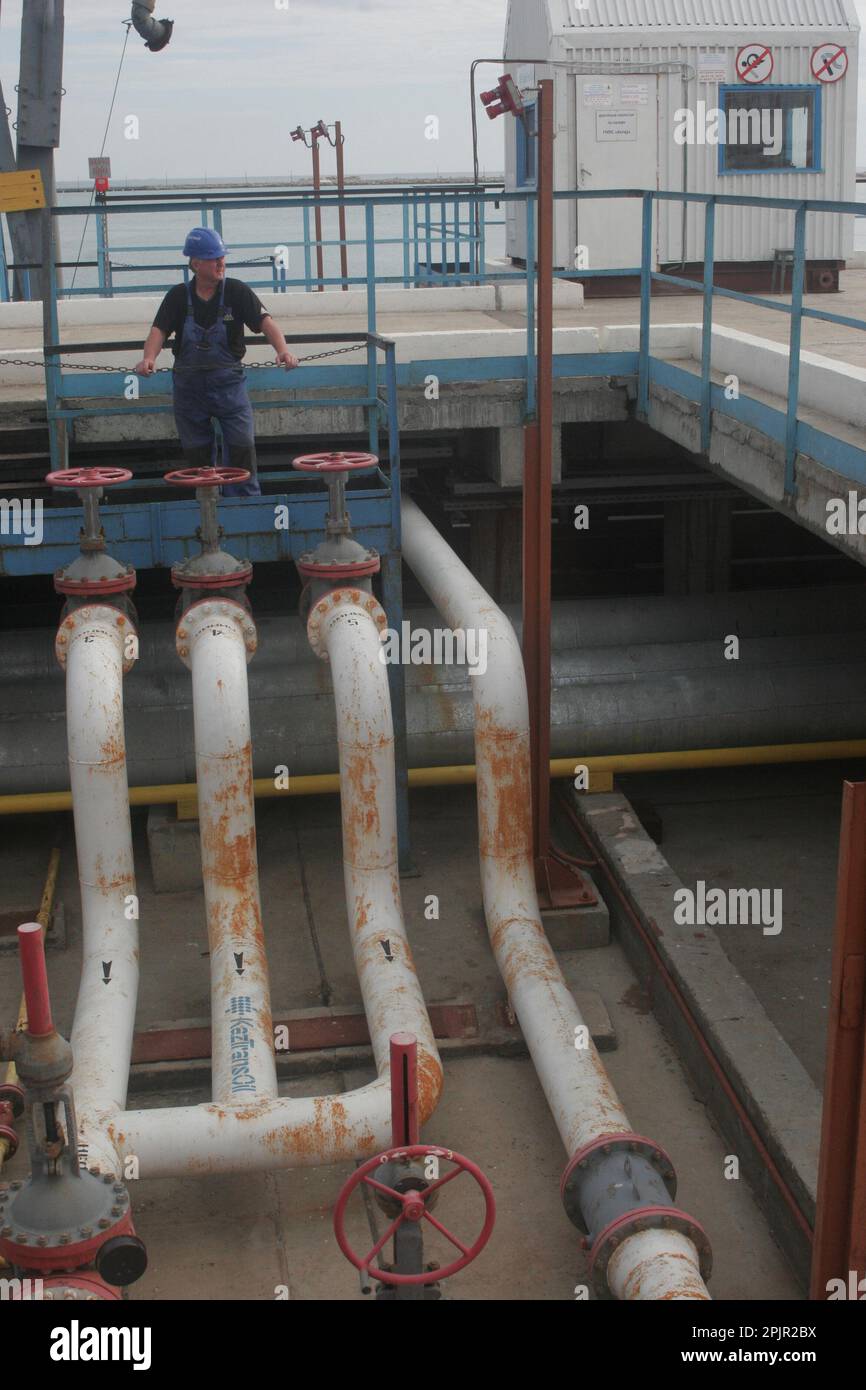 Operatore al terminal di carico di KazTransOil nel porto di Aktau in Kazakistan che invia greggio alle navi che spediscono idrocarburi ad altri terminal marittimi di Caspain Foto Stock