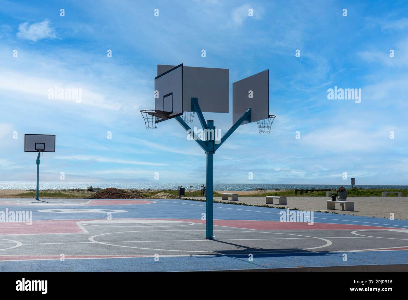Un campo da basket all'aperto accanto alla spiaggia e al lungomare di Vilamoura, Portogallo. Foto Stock