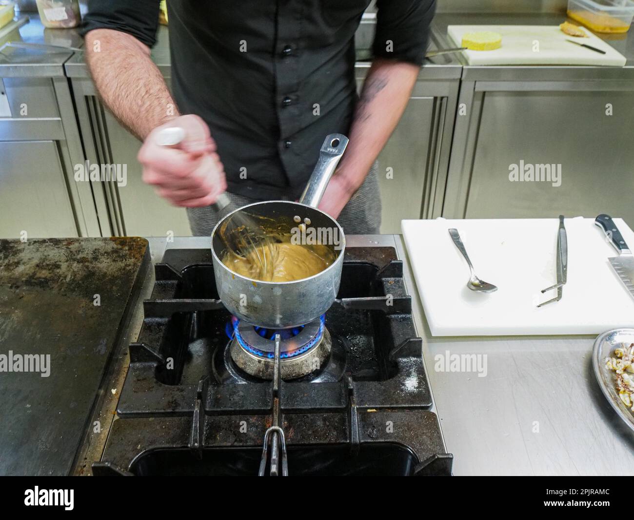 Chef utilizzando un mixer a mano facendo una riduzione crema salsa di patate in una cucina professionale di un ristorante, gourmet concetto di cucina professionale Foto Stock