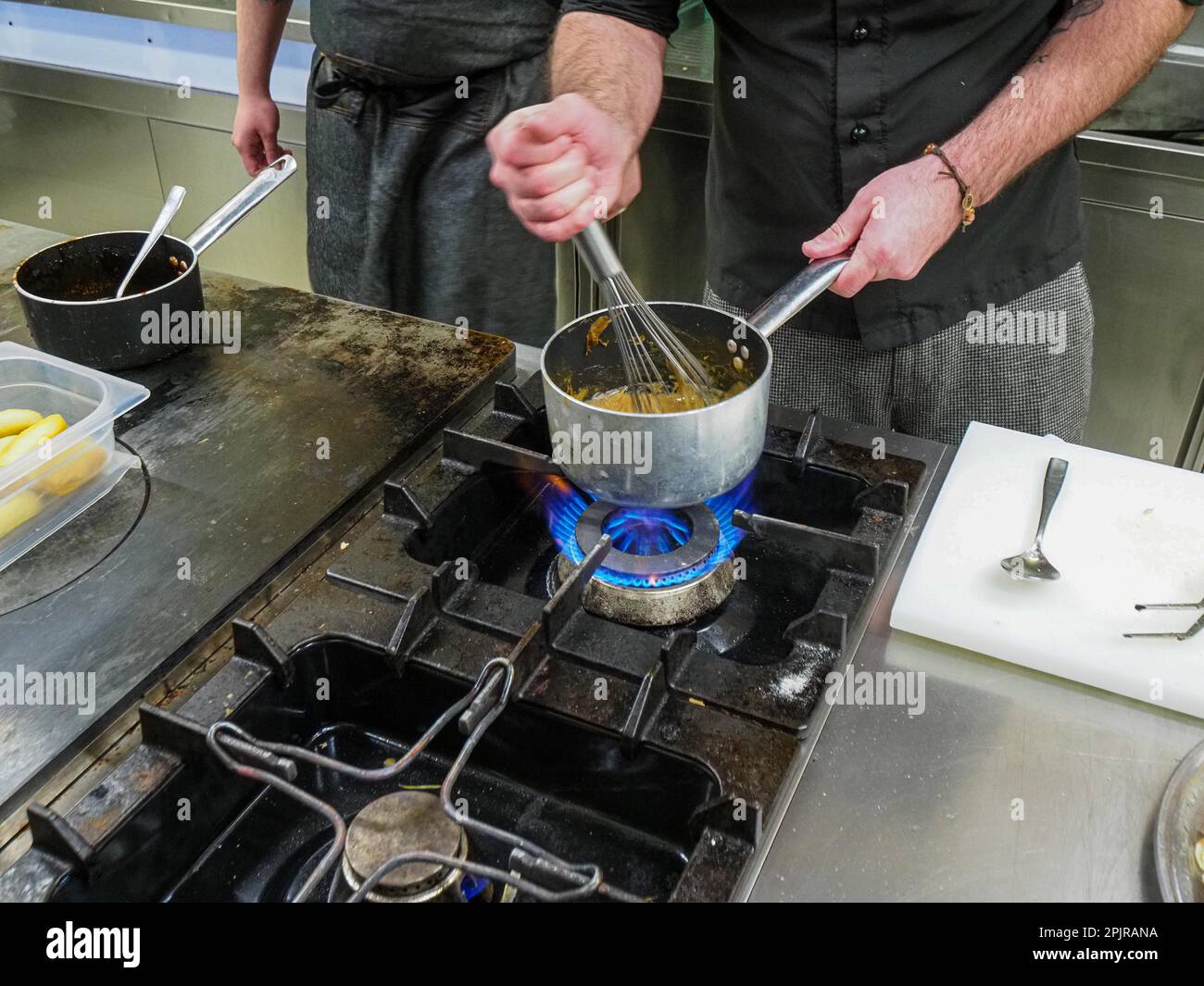 Chef utilizzando un mixer a mano facendo una riduzione crema salsa di patate in una cucina professionale di un ristorante, gourmet concetto di cucina professionale Foto Stock
