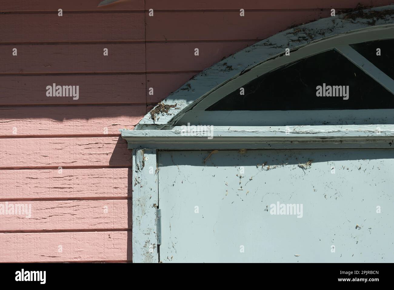 vecchio, intemperie rivestimento e portale decorativo con finestra arrotondata in alto Foto Stock