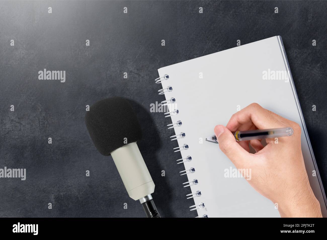 Microfoni e umani scrivono qualcosa sulla carta. Concetto di giornata mondiale della libertà di stampa Foto Stock