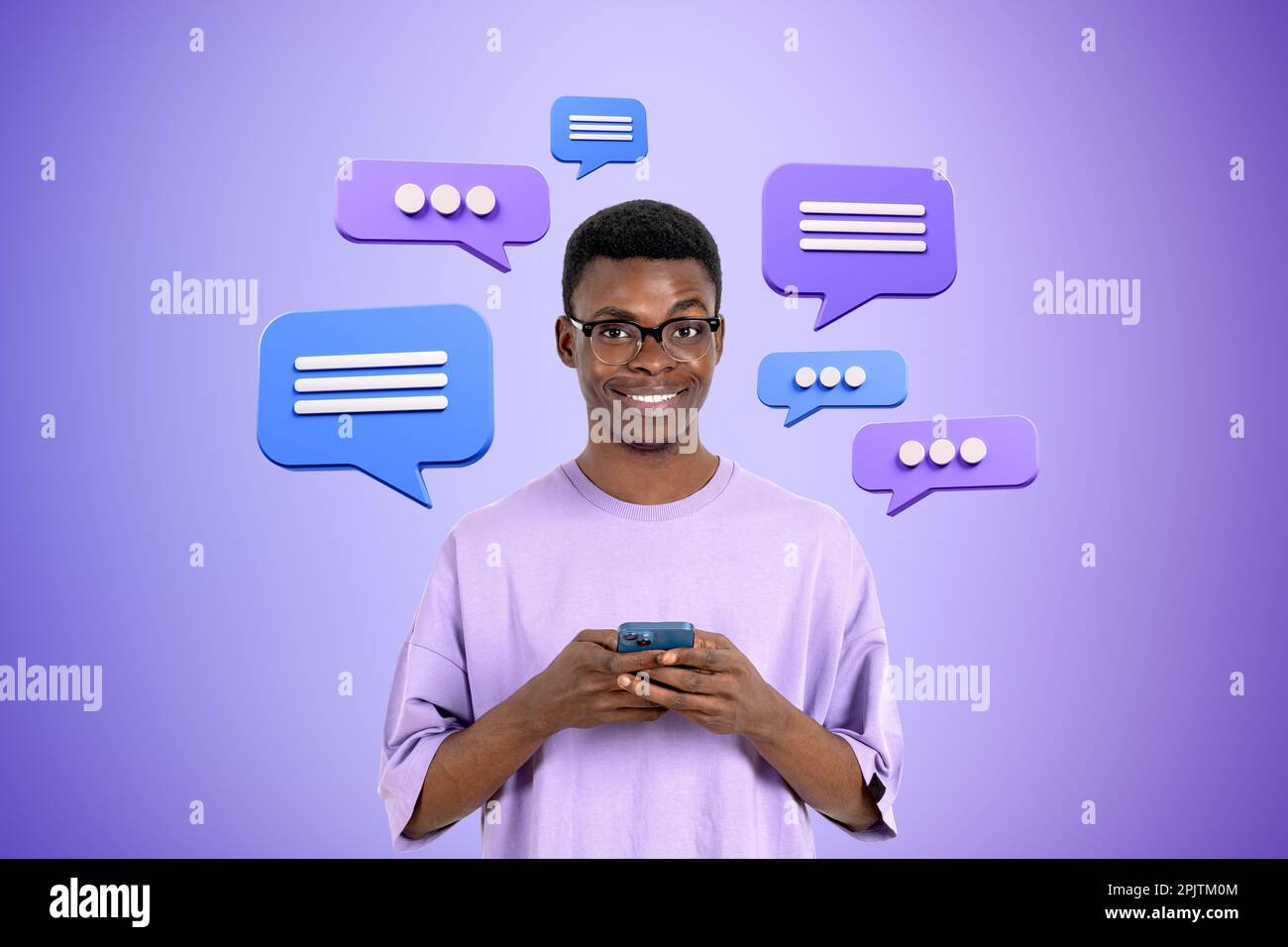 Allegro giovane afroamericano uomo in occhiali con smartphone su sfondo viola con bolle di linguaggio. Concetto di social media e chat Foto Stock