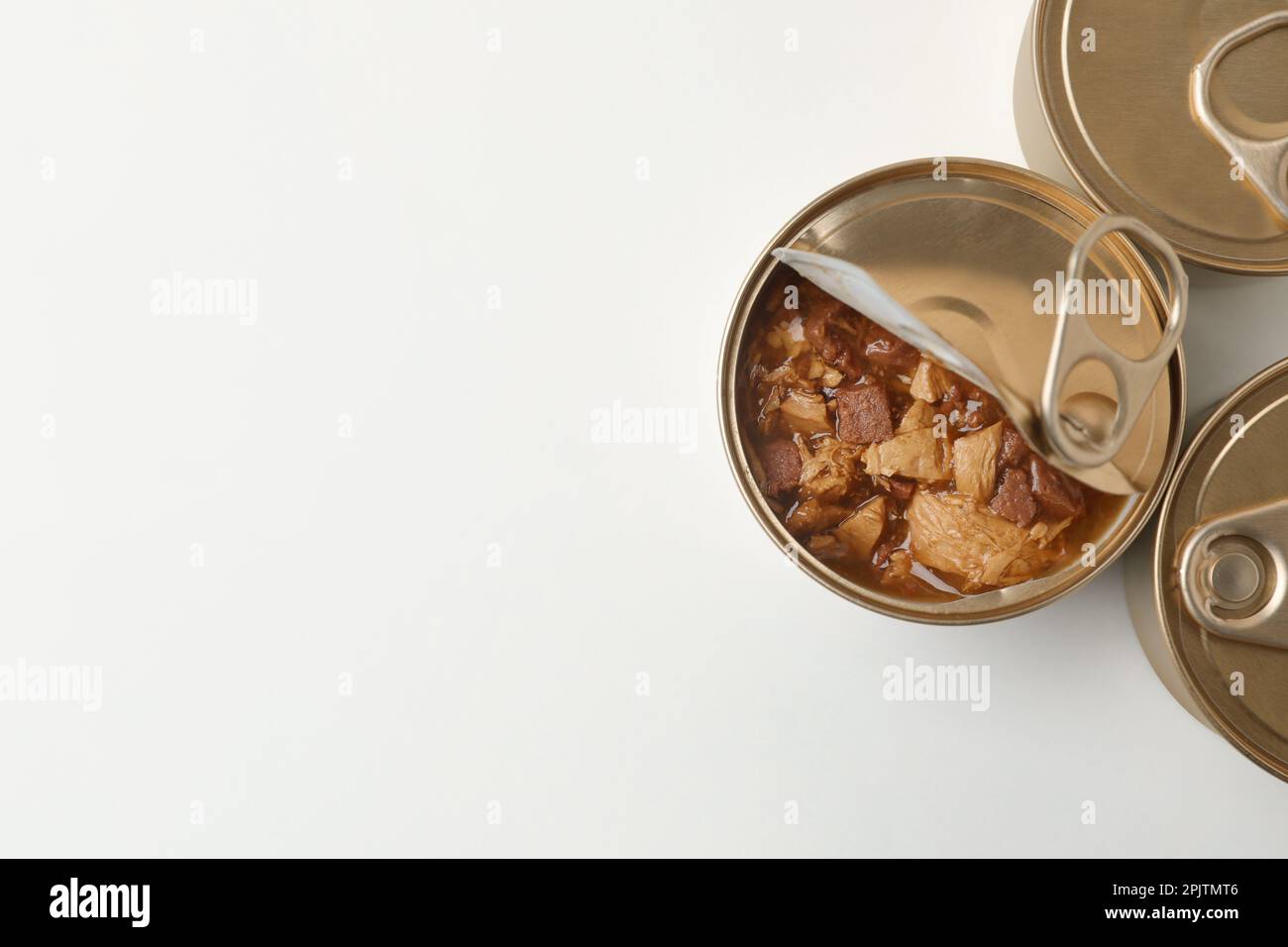 Lattine di lattina con alimenti umidi per gatti su sfondo bianco, vista dall'alto. Spazio per il testo Foto Stock
