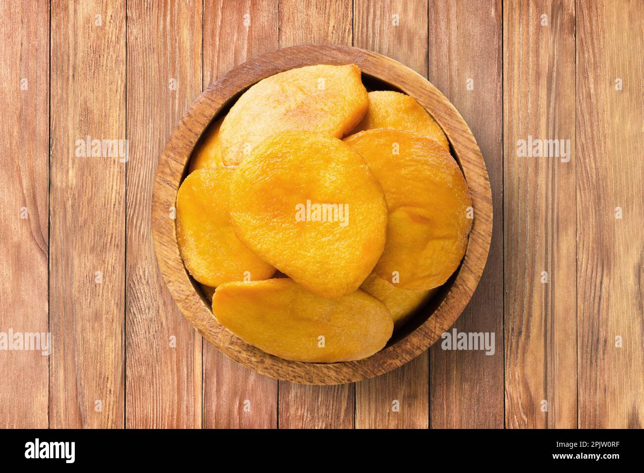 frutta secca, metà pesca in ciotola di legno sullo sfondo della tavola. cibo vegetale sano. Foto Stock