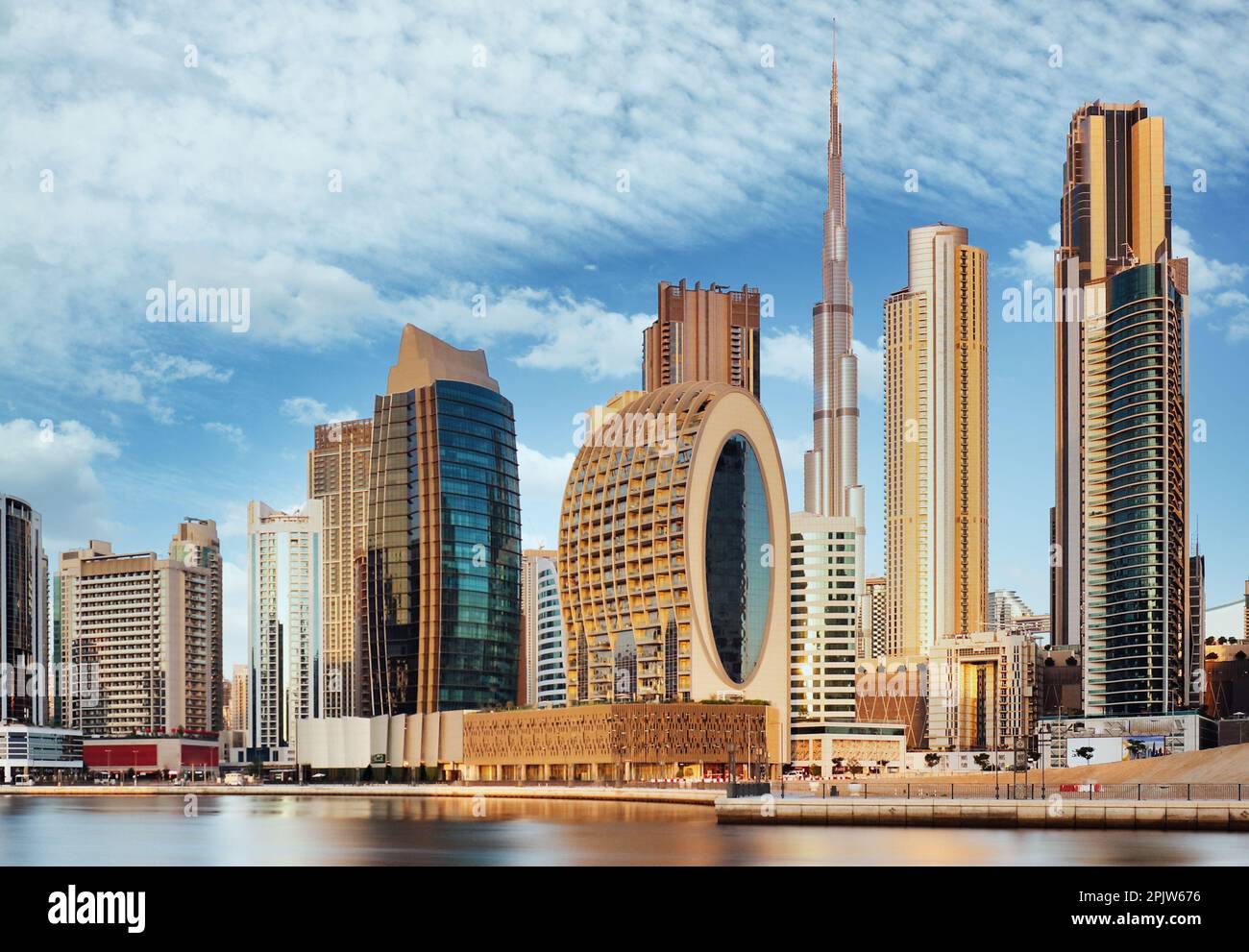 Panorama dello skyline del centro di Dubai con riflessi nel Dubai Creek all'alba, dal lungomare del porto di Dubai Creek. UAR Foto Stock