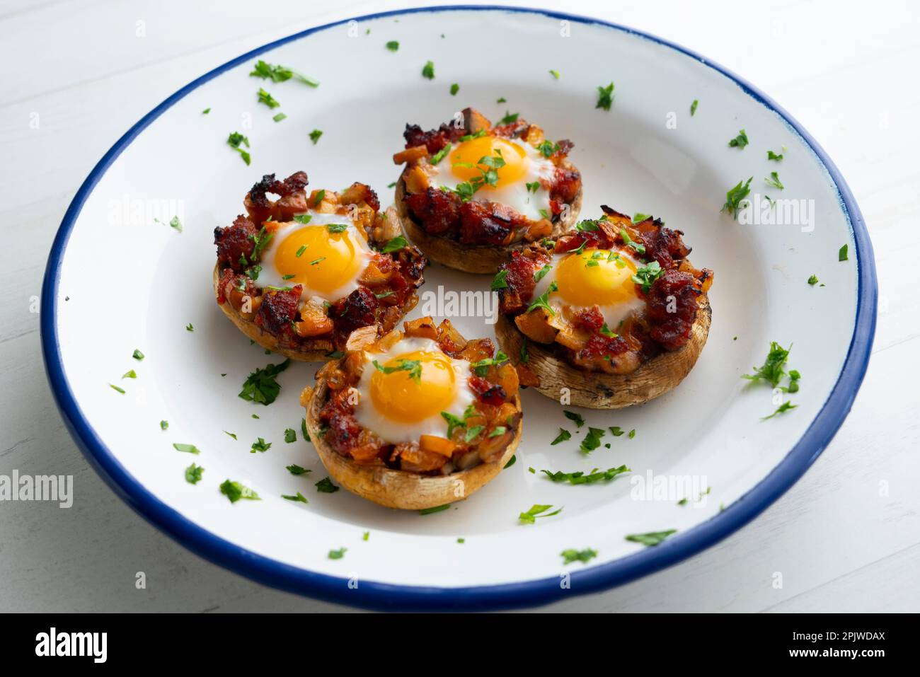 Funghi al forno ripieni di sobrasada e quaglia d'uovo. Tradizionale tapa spagnola. Foto Stock