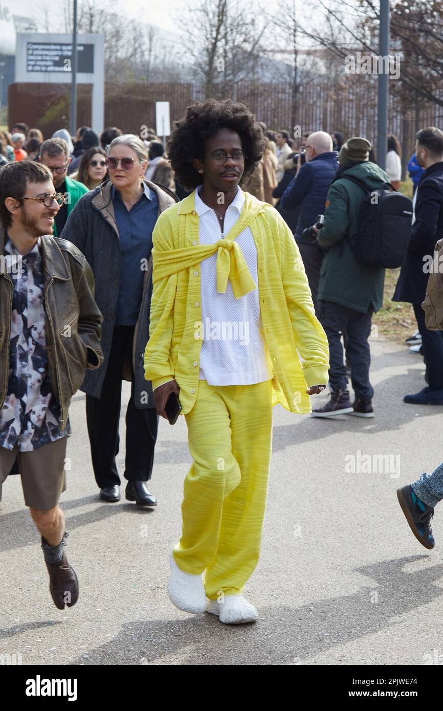 MILANO, ITALIA - 25 FEBBRAIO 2023: Uomo con camicia gialla e pantaloni prima della sfilata Ferragamo, Milano Fashion Week Street Style Foto Stock
