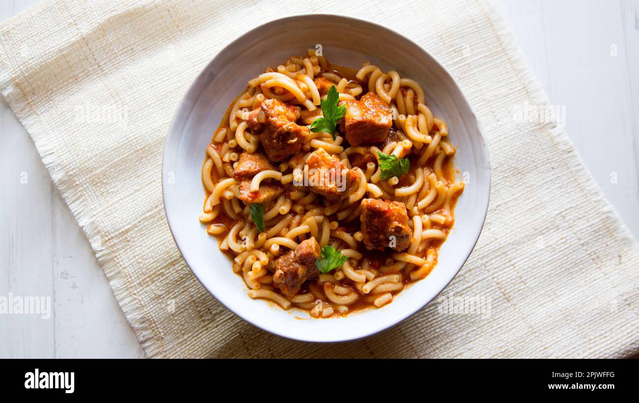 Tagliatelle in casseruola con costolette di maiale. Tradizionale ricetta spagnola di tapa cotta al forno. Foto Stock