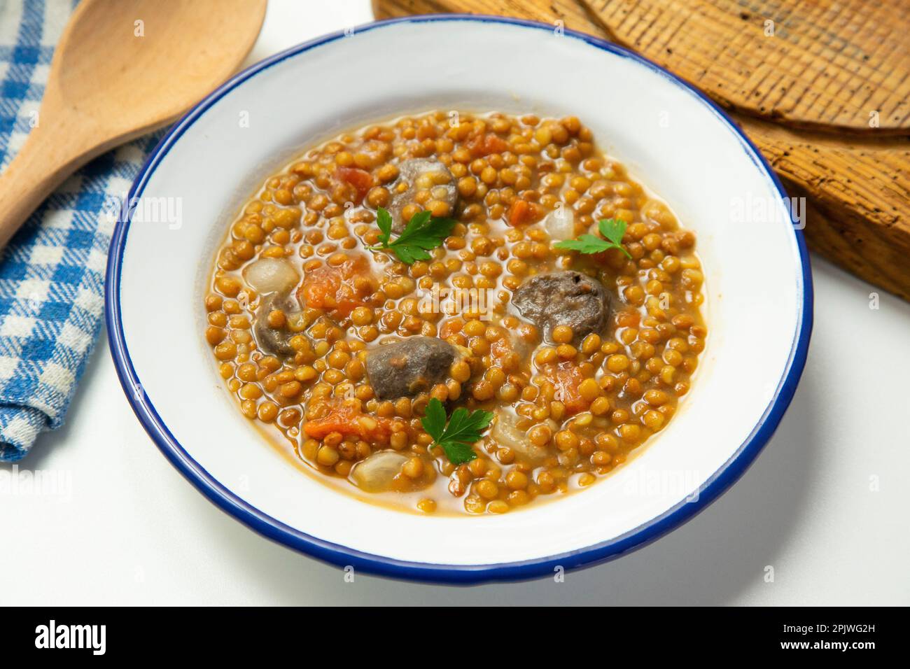Piatto di lenticchie con patate, chorizo e budino nero. Tradizionale stufato di lenticchie spagnole con verdure. Foto Stock
