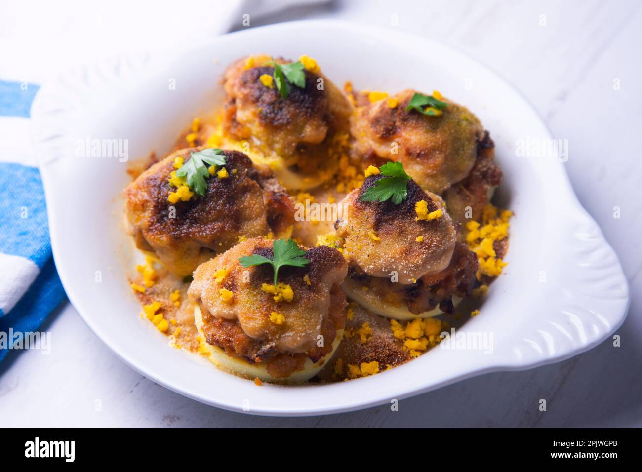 Uova farcite di tonno con besciamella gratinata in forno. Foto Stock