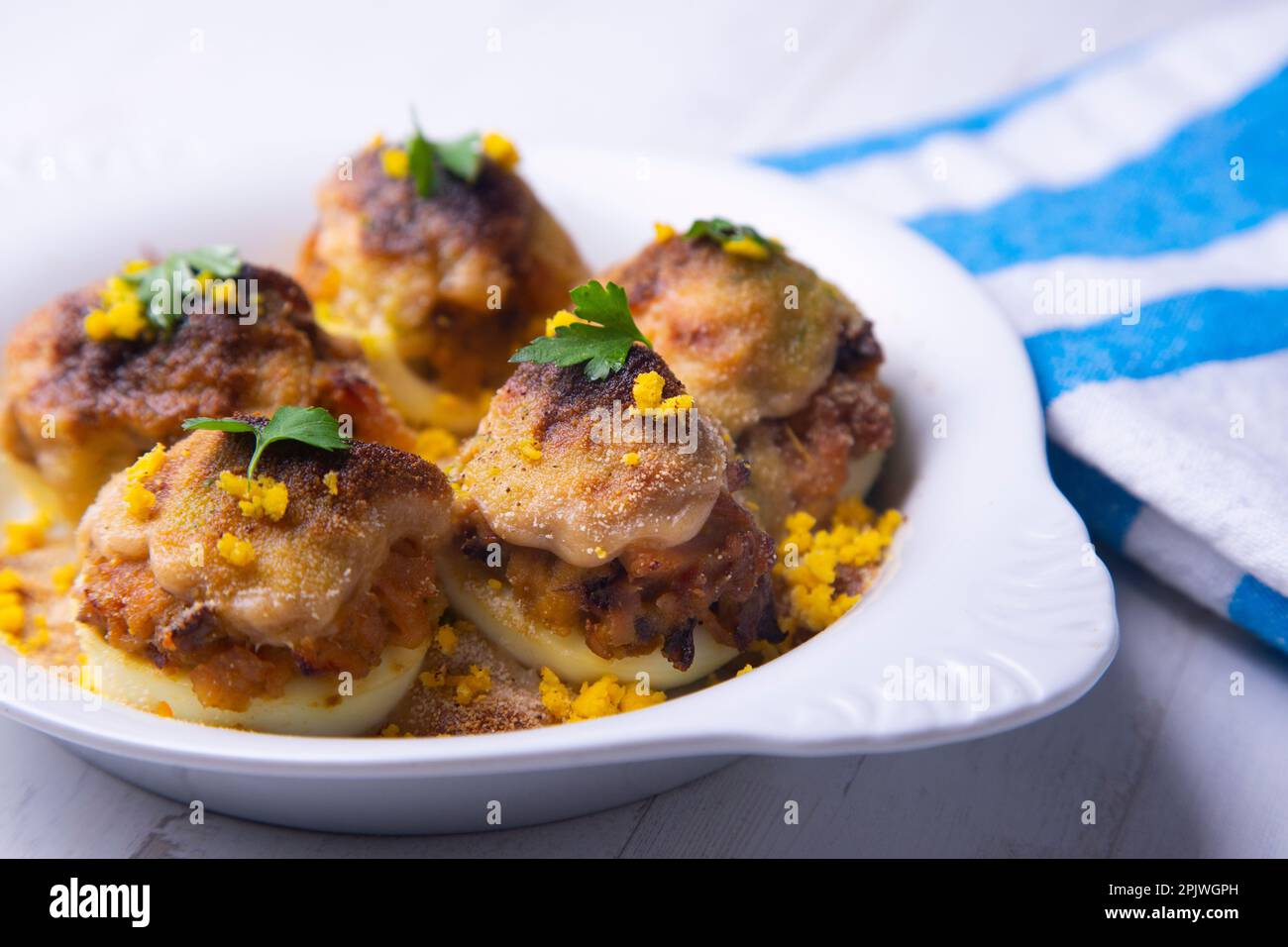 Uova farcite di tonno con besciamella gratinata in forno. Foto Stock