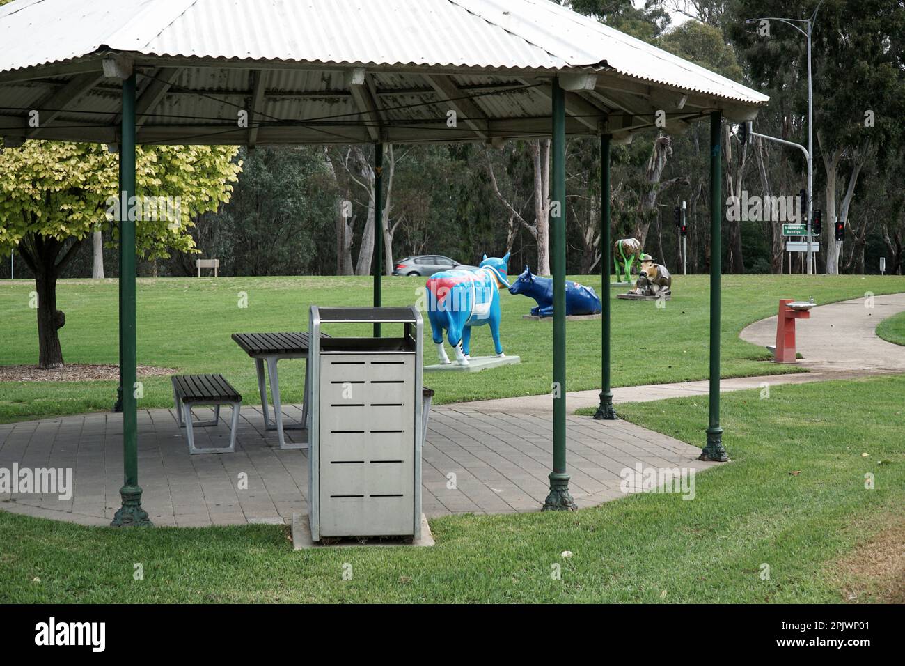 Un rifugio da picnic con tavolo e sedie in un parco pubblico con erba verde. Foto Stock
