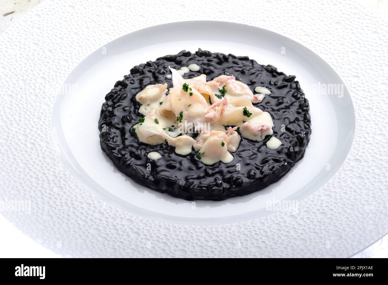 Un piatto di risotto Venere nero con inchiostro di seppie e seppie bollite. Foto Stock