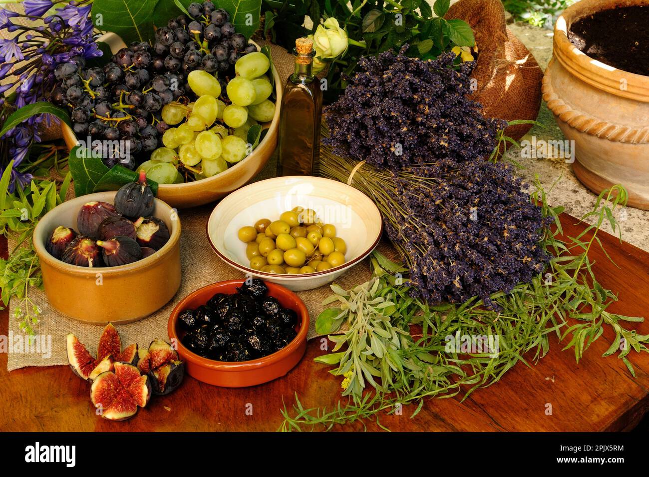 Tavola dei prodotti del giardino provenzale con olive, fichi, uva ed erbe aromatiche, Vaucluse, Francia. Foto Stock